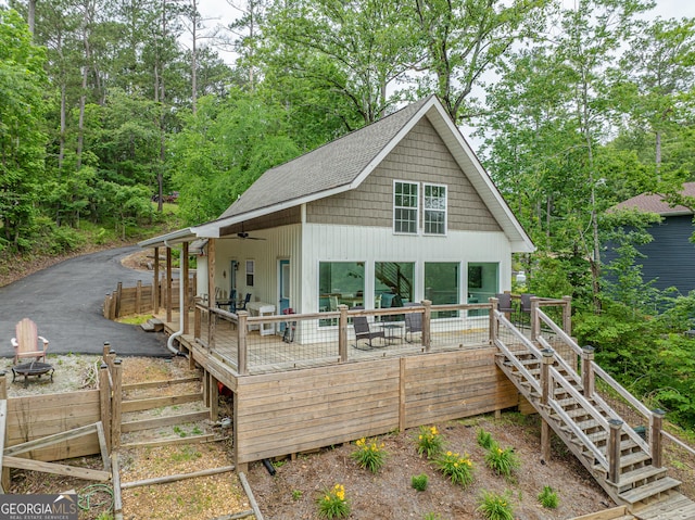 rear view of house featuring stairway, a fire pit, a wooden deck, a ceiling fan, and roof with shingles