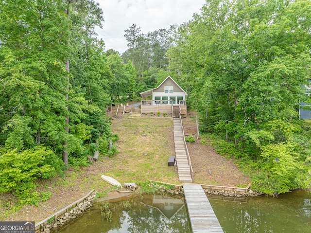 back of property with stairs and a deck with water view