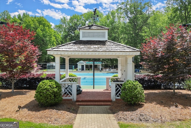 outdoor pool with a gazebo and fence