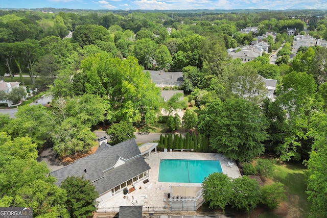 drone / aerial view of a forest and a pool area
