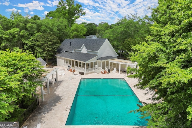 community pool featuring a patio, a pergola, and fence