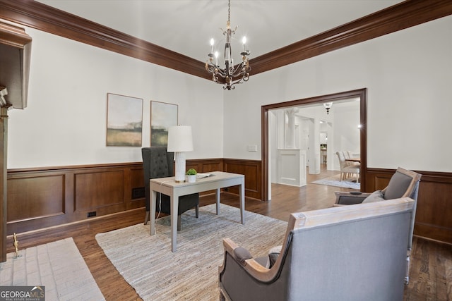 living room featuring wainscoting, crown molding, a chandelier, dark wood-style floors, and an office area