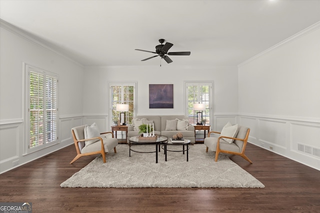 sitting room with ceiling fan, ornamental molding, dark wood-style floors, and a wainscoted wall