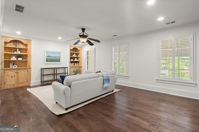 living area featuring baseboards, crown molding, dark wood-type flooring, ceiling fan, and recessed lighting