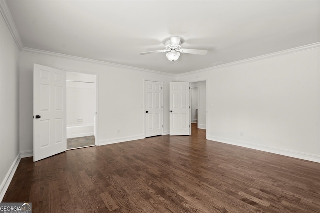 unfurnished bedroom with dark wood-type flooring, crown molding, baseboards, ensuite bath, and ceiling fan