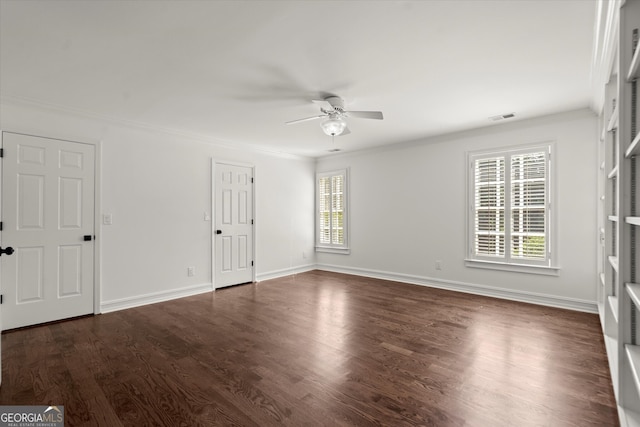 empty room with ceiling fan, ornamental molding, dark wood-style flooring, and baseboards