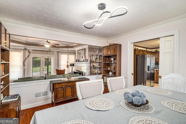 dining area with crown molding, wood finished floors, and french doors