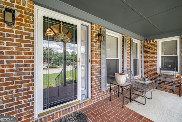 property entrance with brick siding and covered porch