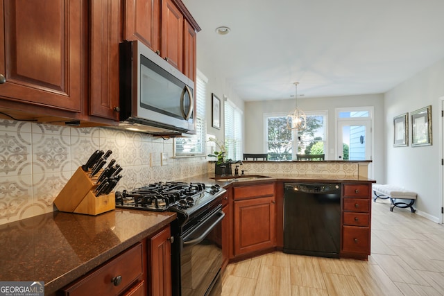 655 Grove Manor Ct, Suwanee, GA 30024 - kitchen featuring black appliances, plenty of natural light, a peninsula, and backsplash