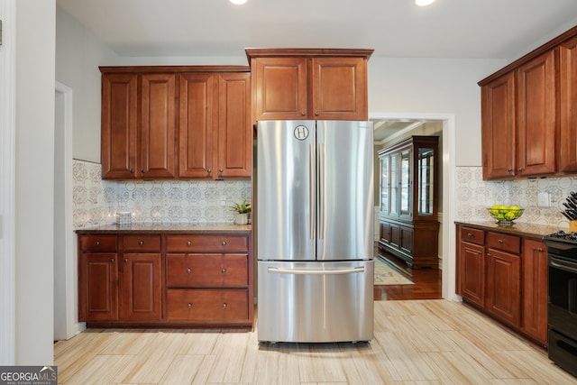 655 Grove Manor Ct, Suwanee, GA 30024 - kitchen featuring freestanding refrigerator, range, dark stone countertops, recessed lighting, and decorative backsplash