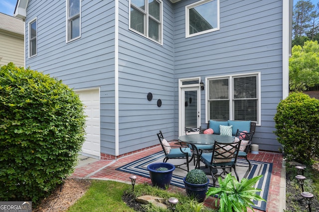 655 Grove Manor Ct, Suwanee, GA 30024 - view of patio featuring outdoor dining area and a garage