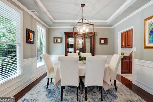 655 Grove Manor Ct, Suwanee, GA 30024 - dining area with healthy amount of natural light, dark wood-style flooring, a chandelier, a wainscoted wall, and a raised ceiling