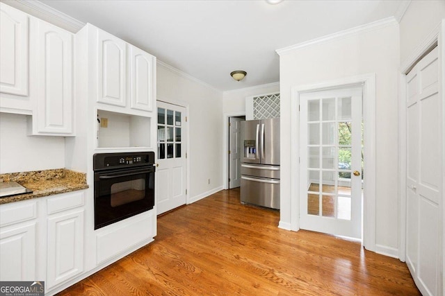 kitchen featuring stainless steel fridge with ice dispenser, black oven, ornamental molding, stone counters, and white cabinets