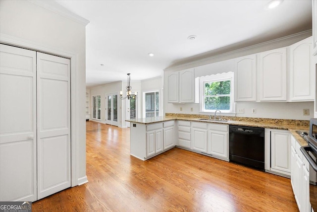 kitchen featuring black dishwasher, a sink, a peninsula, white cabinetry, and a chandelier