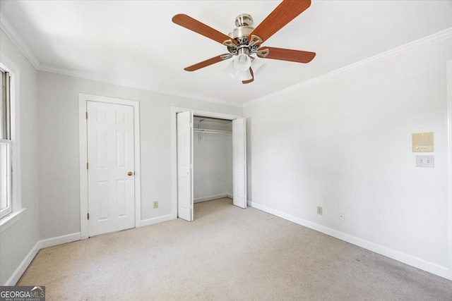 unfurnished bedroom featuring ornamental molding, light colored carpet, baseboards, a ceiling fan, and a closet