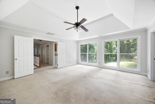 unfurnished living room featuring a tray ceiling, ornamental molding, carpet flooring, ceiling fan, and baseboards