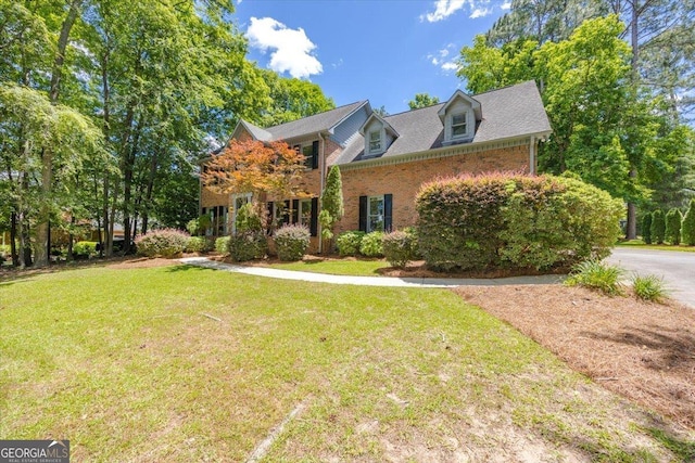 view of front of home with a front lawn and brick siding