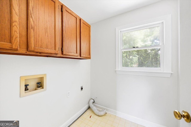 washroom featuring cabinet space, hookup for a washing machine, electric dryer hookup, and baseboards