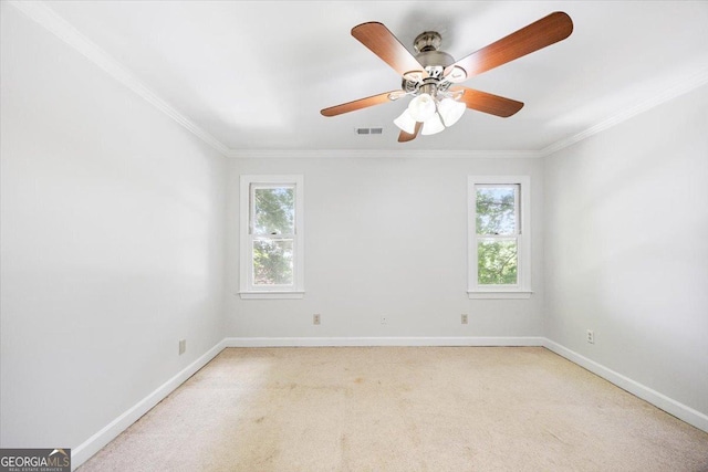 spare room with ornamental molding, light colored carpet, baseboards, and a ceiling fan