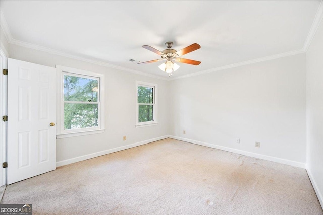 empty room featuring baseboards, ornamental molding, carpet, and a ceiling fan