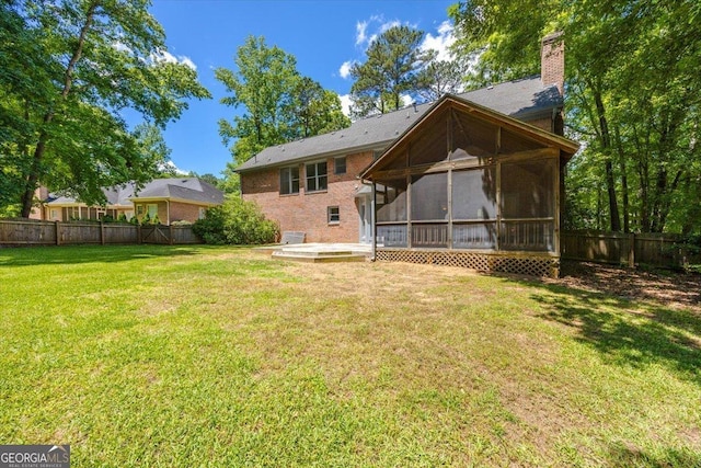 back of property with a sunroom, a chimney, and brick siding