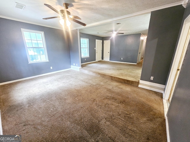 unfurnished room with a ceiling fan, carpet floors, baseboards, ornamental molding, and a textured ceiling