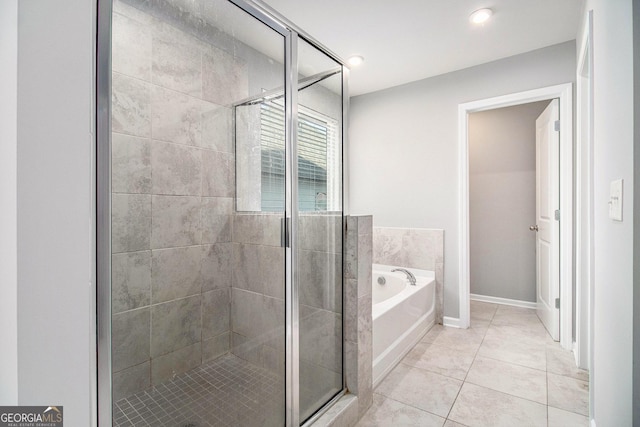 2769 Morgan Spring Trl, Buford, GA 30519 - full bathroom featuring a garden tub, a stall shower, tile patterned floors, and baseboards