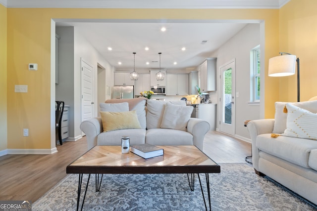 living area featuring light wood-style floors, baseboards, and recessed lighting