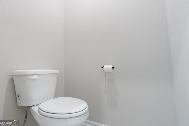 bathroom with baseboards and toilet