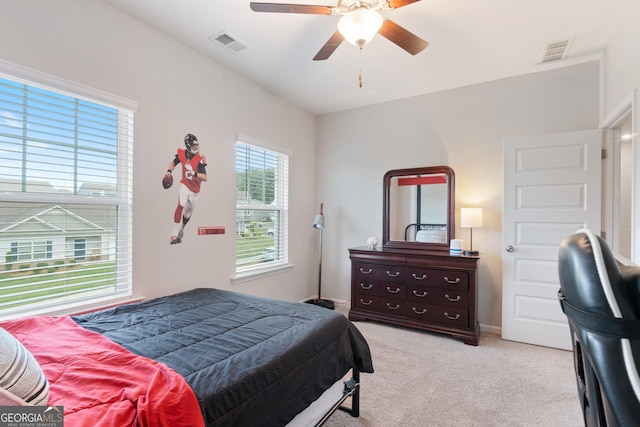 bedroom featuring light carpet and a ceiling fan