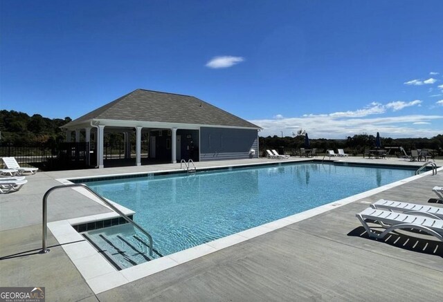 community pool featuring a patio area and fence