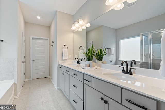 bathroom with tile patterned flooring, double vanity, a bath, and baseboards