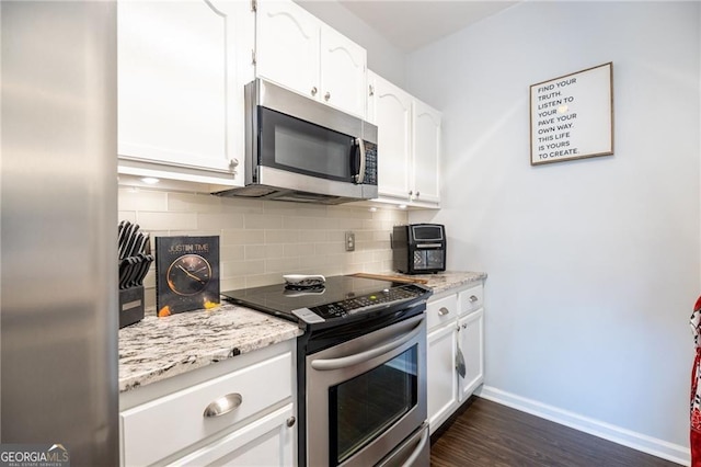2700 Pine Tree Rd NE Unit 2204, Atlanta, GA 30324 - kitchen with appliances with stainless steel finishes, dark wood-type flooring, white cabinetry, and backsplash