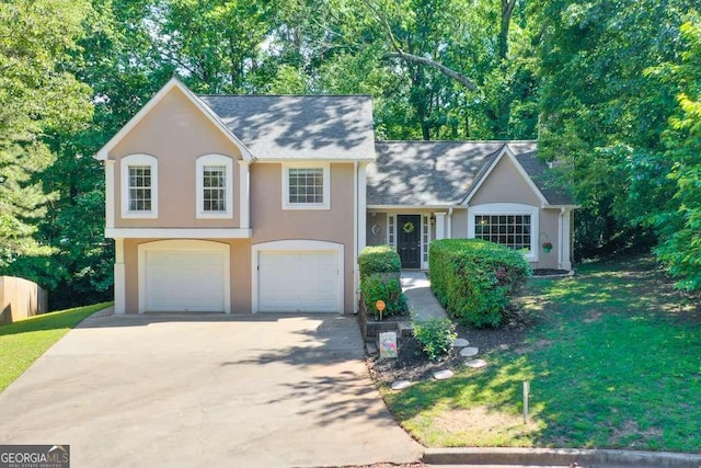 tri-level home featuring stucco siding, an attached garage, driveway, and a front lawn