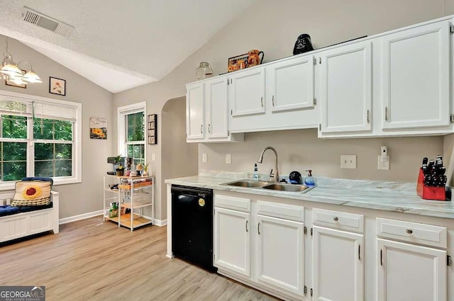 kitchen with dishwasher, a sink, vaulted ceiling, light countertops, and light wood-type flooring