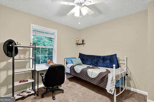 carpeted bedroom featuring baseboards, a ceiling fan, a textured ceiling, and a desk