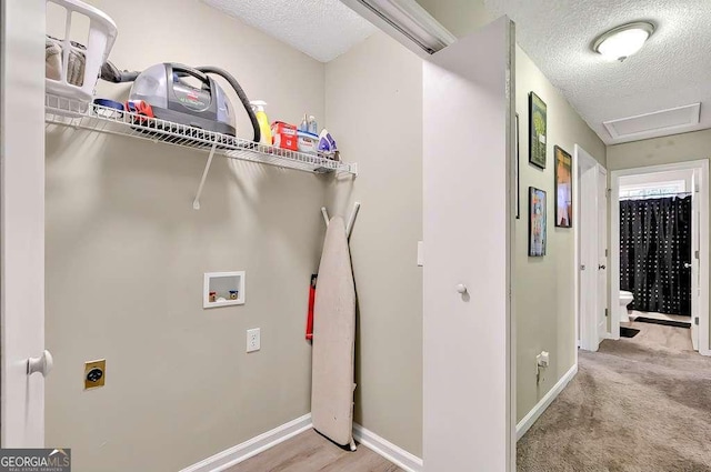 washroom featuring hookup for a washing machine, a textured ceiling, hookup for an electric dryer, baseboards, and carpet floors
