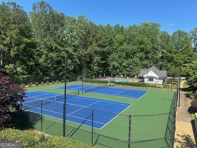 view of tennis court with fence and community basketball court