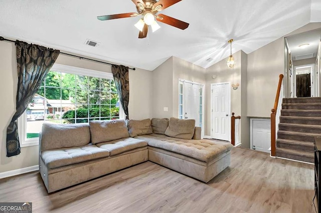 living area featuring wood finished floors, lofted ceiling, a ceiling fan, stairs, and baseboards