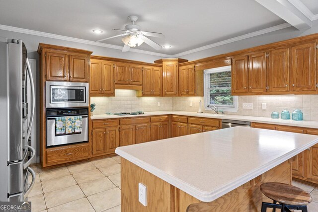 510 Jenna Trl, Mcdonough, GA 30252 - kitchen featuring stainless steel appliances, brown cabinets, light countertops, a ceiling fan, and crown molding