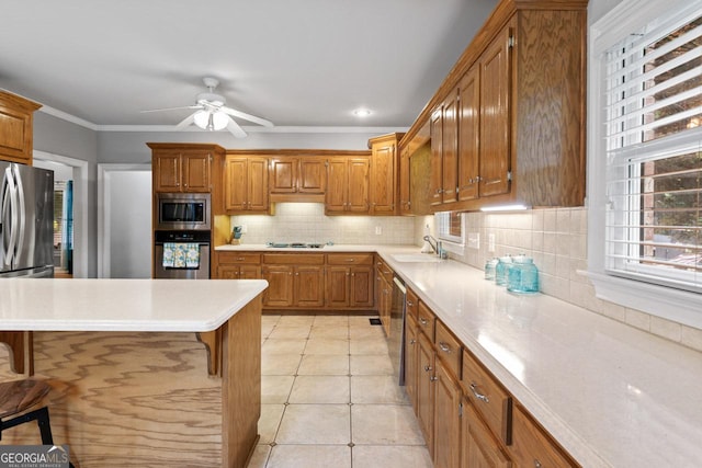 510 Jenna Trl, Mcdonough, GA 30252 - kitchen featuring stainless steel appliances, brown cabinetry, plenty of natural light, and crown molding