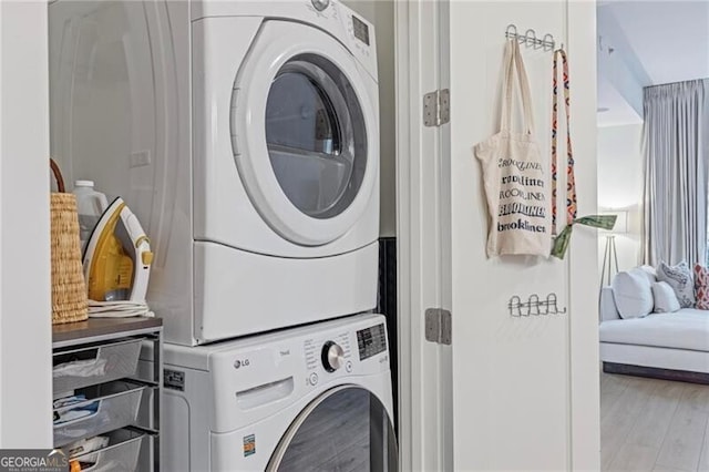 1820 Peachtree St Unit 311, Atlanta, GA 30309 - clothes washing area with estacked washer and dryer and wood finished floors