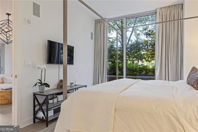 1820 Peachtree St Unit 311, Atlanta, GA 30309 - bedroom with wood finished floors, expansive windows, and baseboards