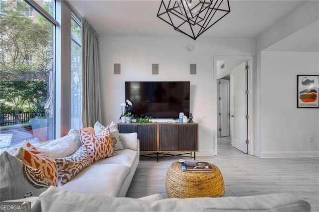 1820 Peachtree St Unit 311, Atlanta, GA 30309 - living room featuring a chandelier, baseboards, and wood finished floors