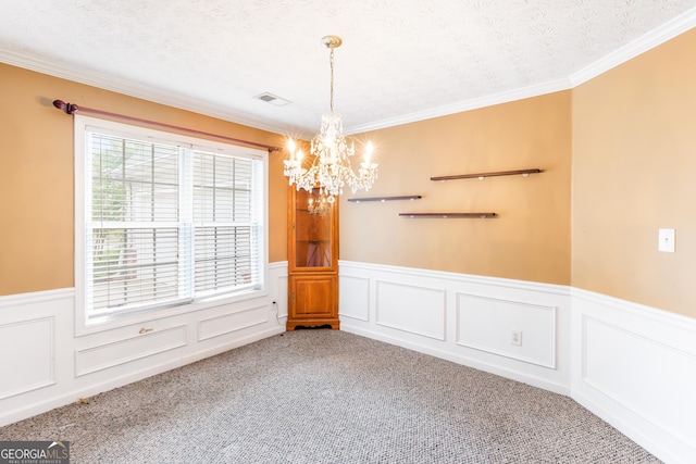 unfurnished room with a chandelier, carpet flooring, wainscoting, crown molding, and a textured ceiling