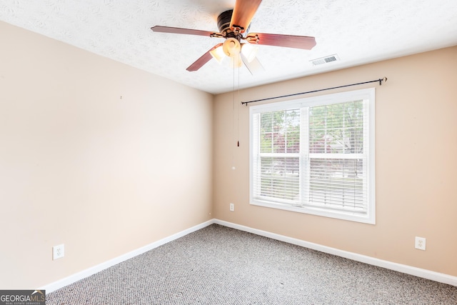 empty room featuring baseboards, carpet floors, ceiling fan, and a textured ceiling