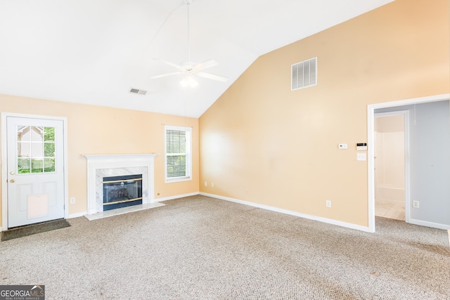 unfurnished living room with ceiling fan, plenty of natural light, lofted ceiling, carpet, and a high end fireplace