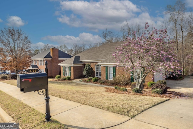 view of front facade featuring brick siding and a front lawn