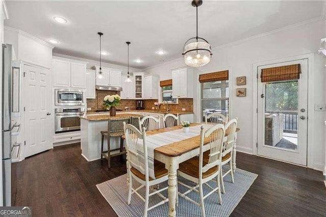 dining space with crown molding, dark wood finished floors, a chandelier, and recessed lighting