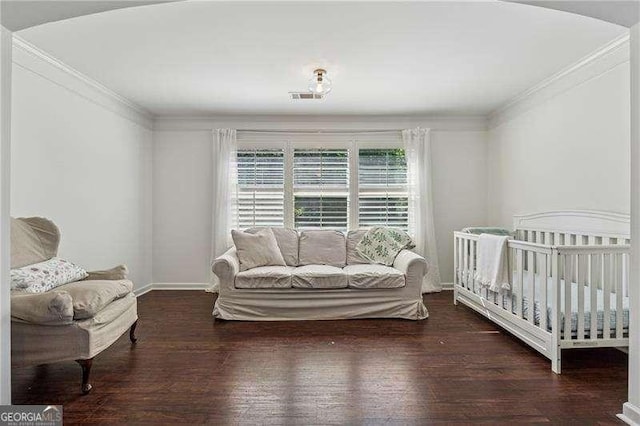 bedroom with wood finished floors, ornamental molding, and baseboards